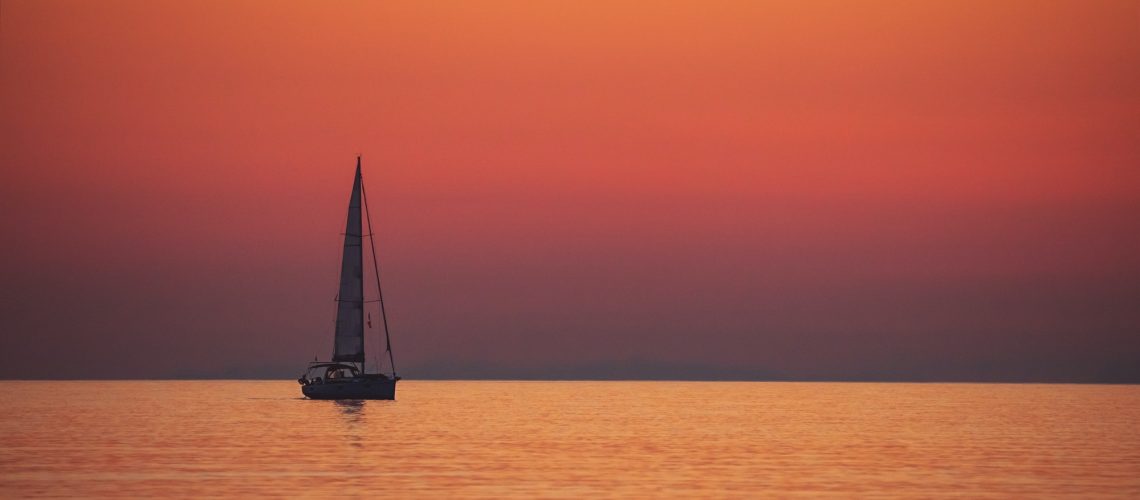 Sail boat over sunset